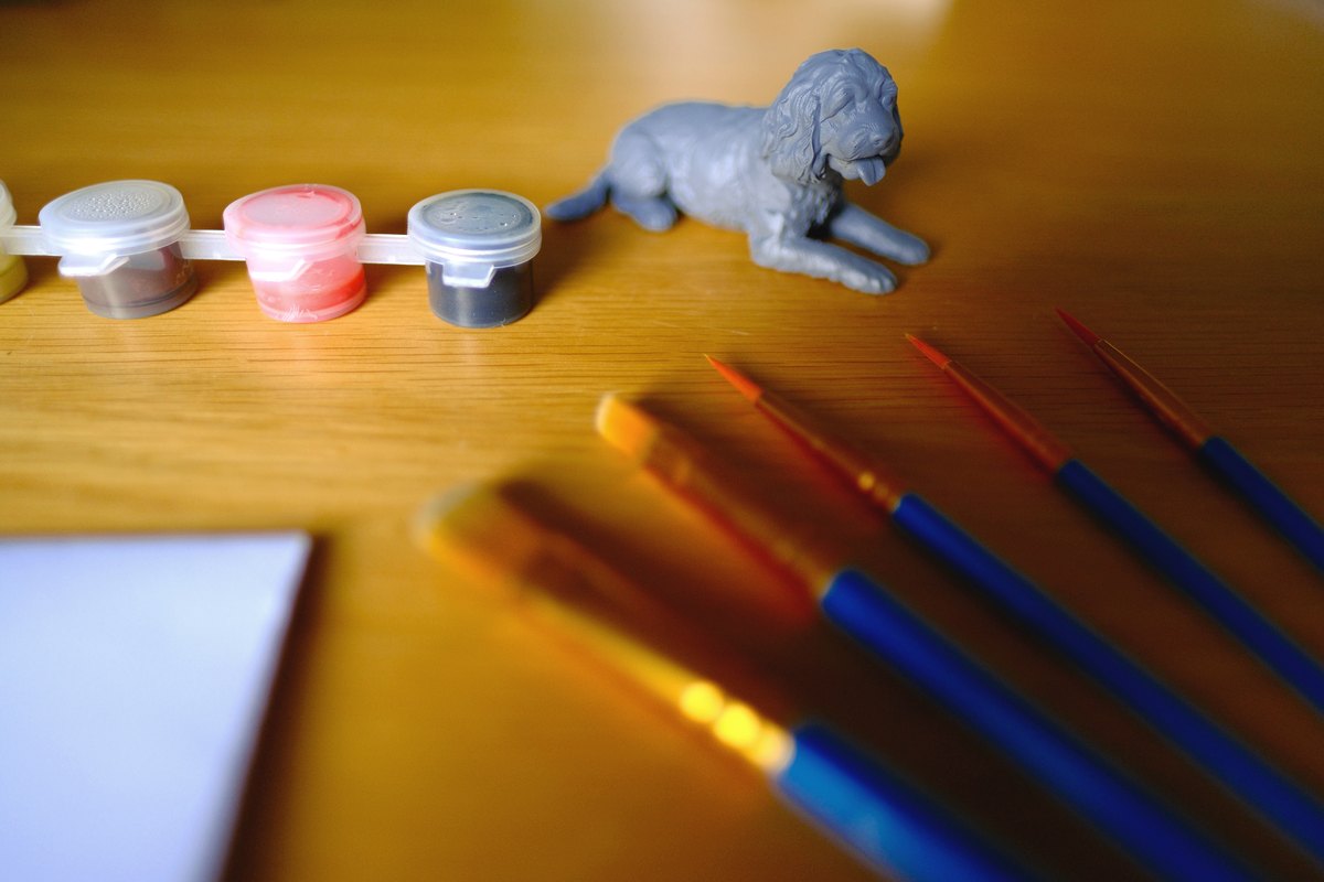 Grey primed resin pet figurine with paints and paint brushes
